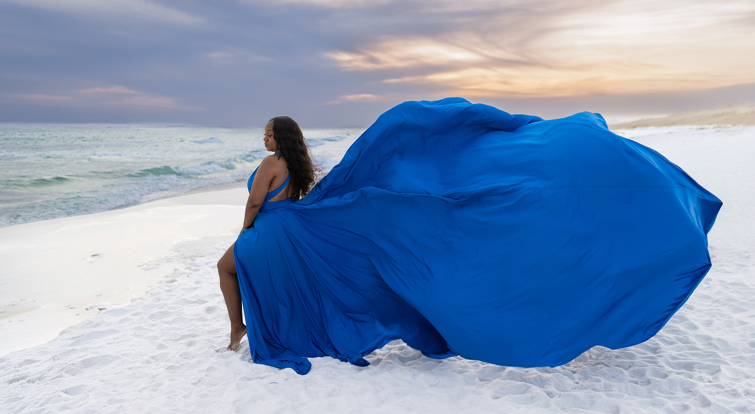 FLYING~1 Woman in a royal blue flying dress on a white-sand beach at sunset