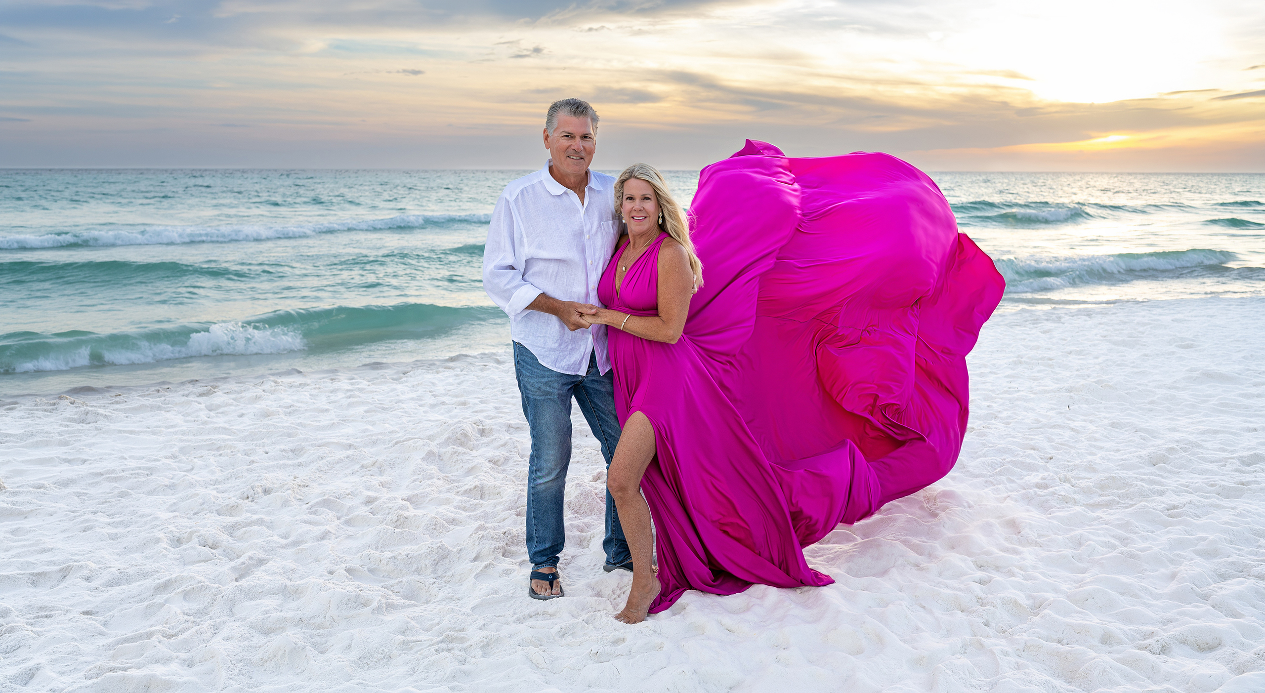 SUNSET~1 Couple on the beach at sunset, the woman in a magenta flying dress