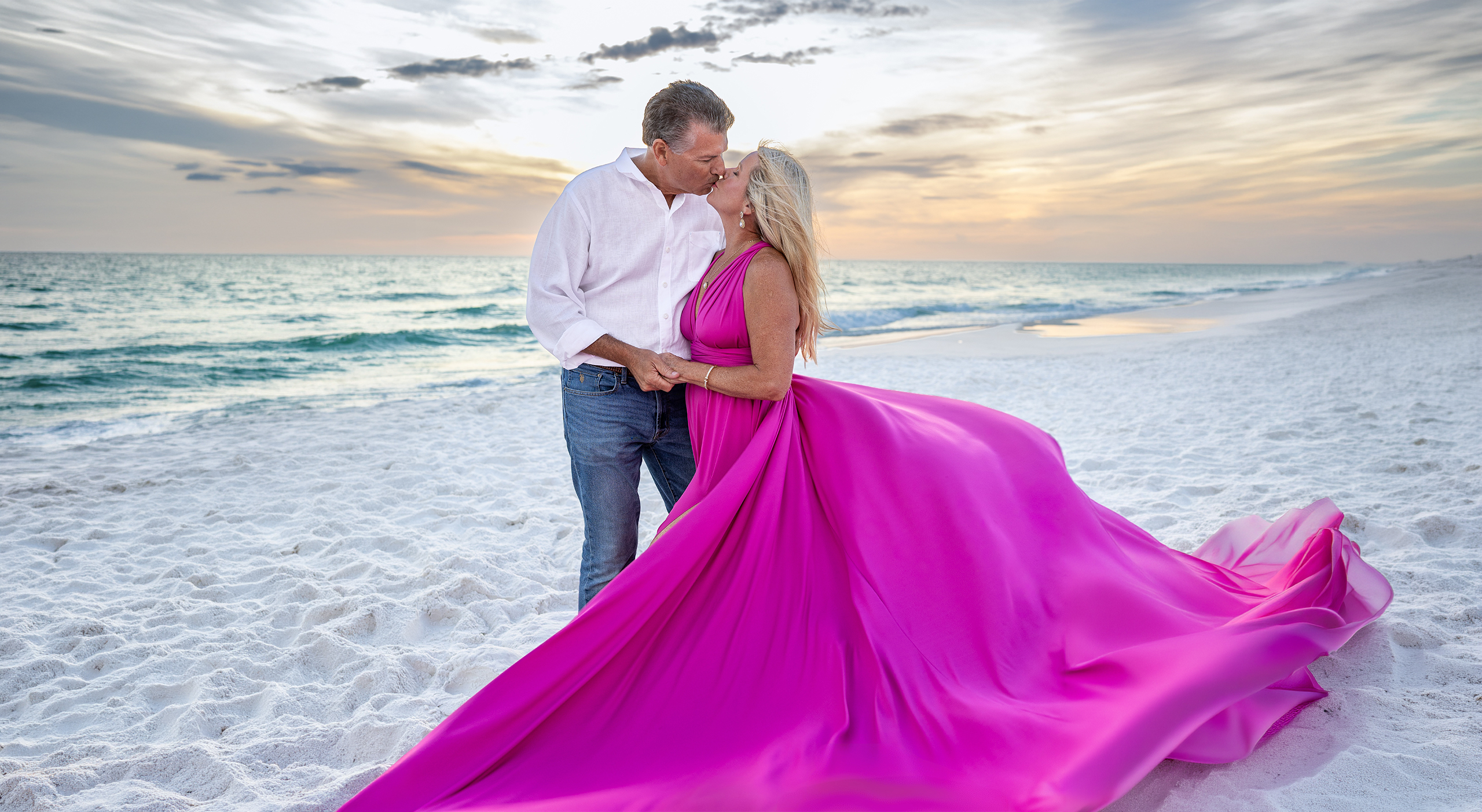 SUNSET~3 Couple kissing on the beach at sunset, the woman in a magenta flying dress