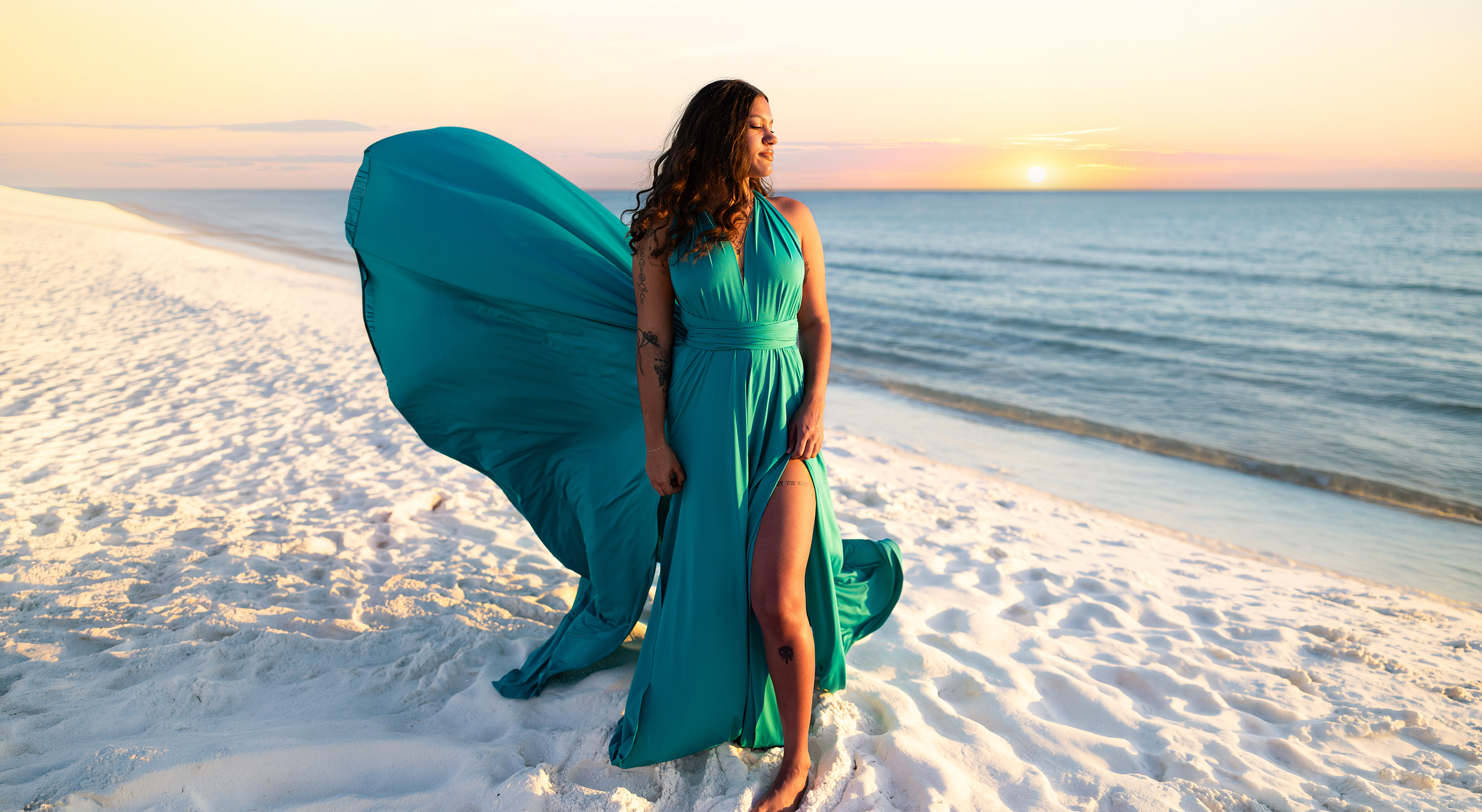 TEALED~1 Woman in a teal flying dress on a white-sand beach